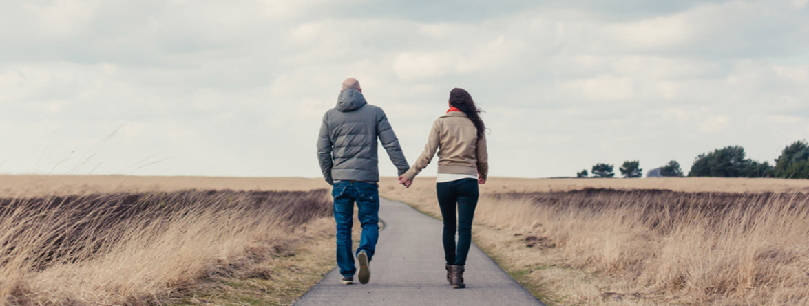 man and woman walking together holding hands