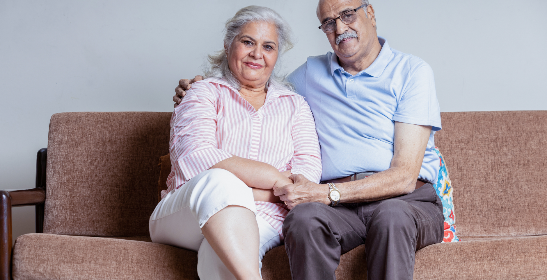 couple sitting together on couch holding each other.