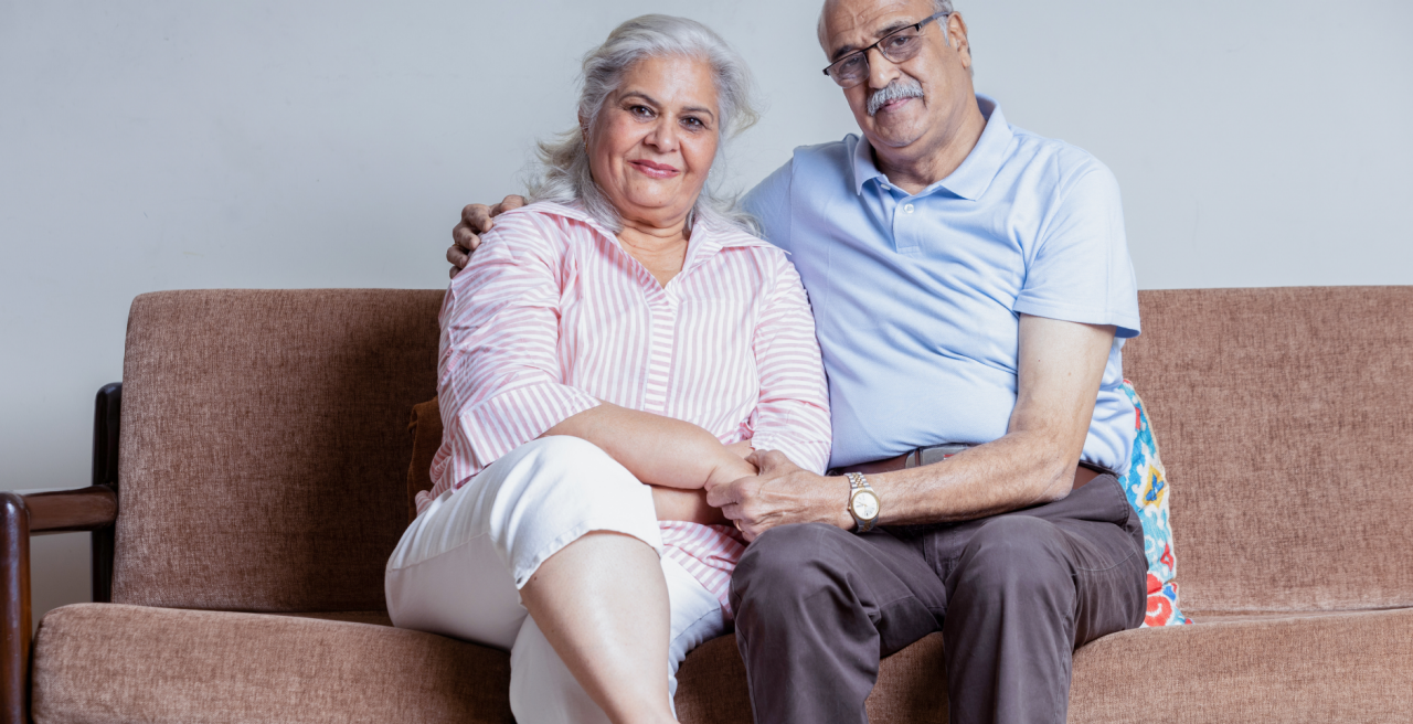 couple sitting together on couch holding each other.